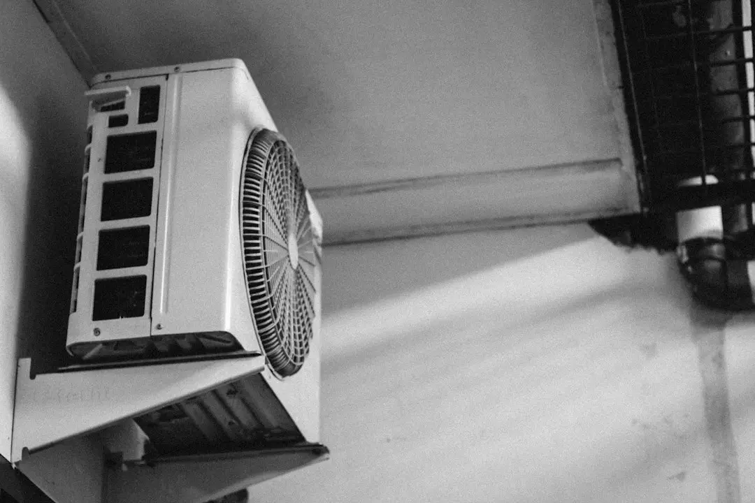 HVAC technician inspecting a newly installed modern eco-friendly AC system outside a residence HVAC technician inspecting a newly installed modern eco-friendly AC system outside a residence