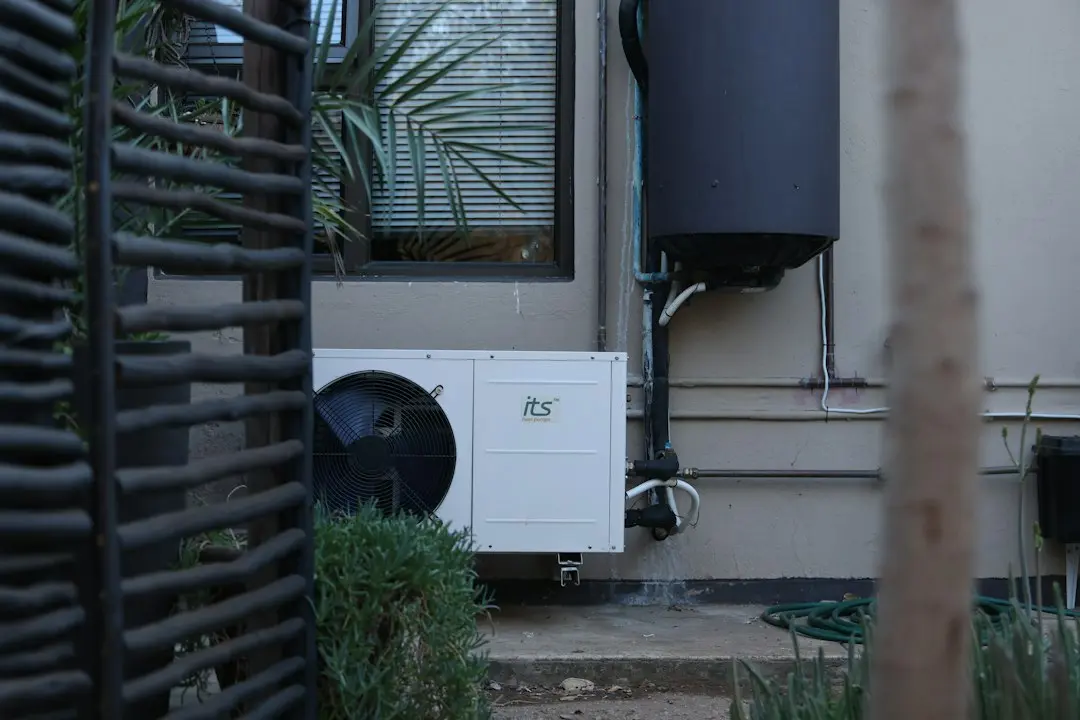 A technician inspecting a hybrid heat pump water heater in a basement utility space