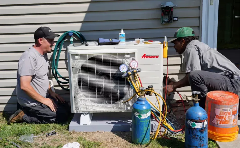 Sureway technician charging a newly installed outdoor AC condenser