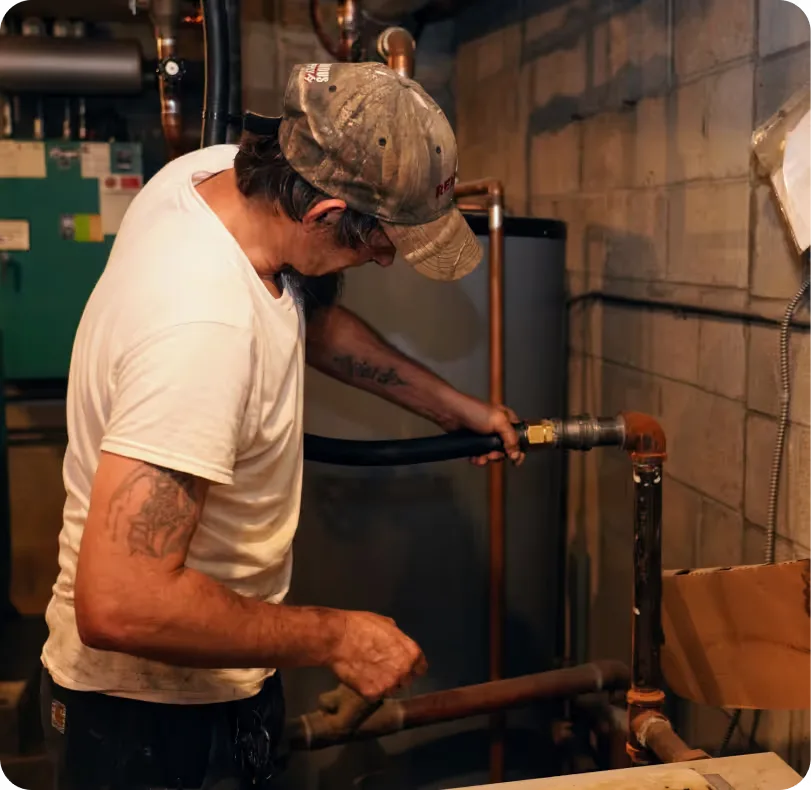 Technician servicing copper connections on a water heater