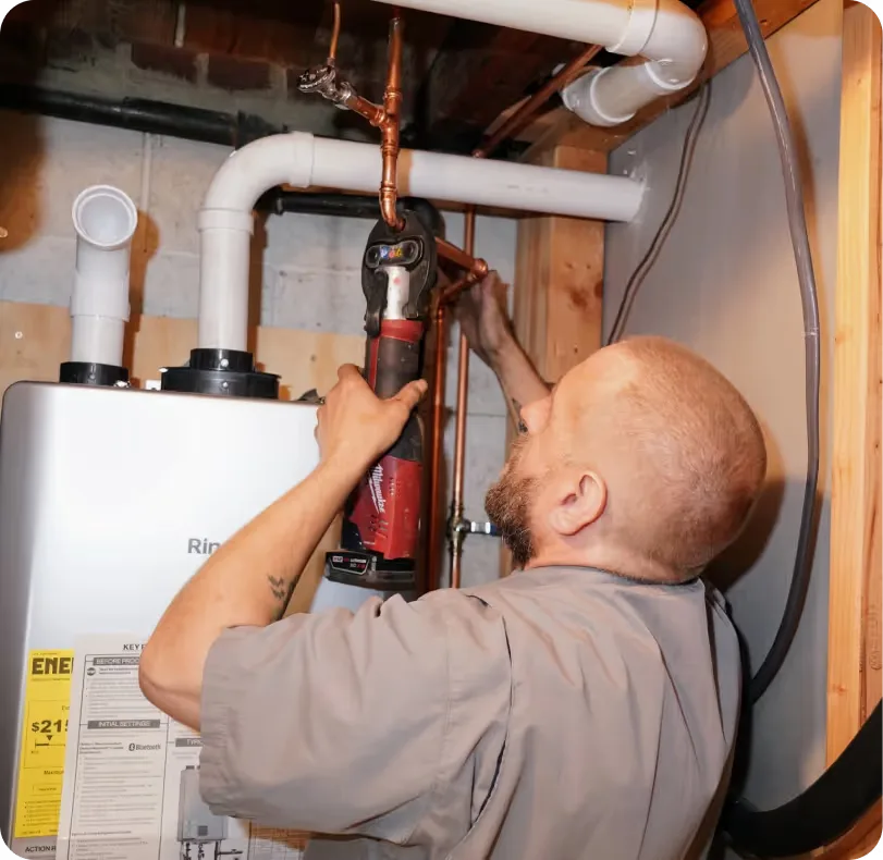 Technician installing a wall-mounted tankless water heater